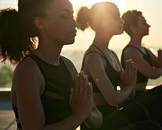 Frauen meditieren bei Sonnenaufgang in ruhiger Atmosphäre – Yoga, Achtsamkeit und Balance erleben I WUNDERORTE“