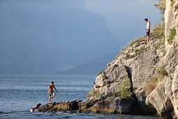 Junge Menschen an einer felsigen Badebucht beim Klippenspringen in der Nähe von Arco am Gardasee – Naturerlebnis und Abenteuerurlaub I WUNDERORTE