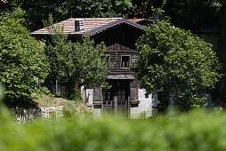Altes Holzhaus inmitten von Bäumen in einer abgelegenen Bergsiedlung bei Arco am Gardasee – authentischer Rückzugsort für Naturliebhaber I WUNDERORTE  Möchtest du daraus auch einen kurzen Anreißertext für eine Zwischenüberschrift oder Bildunterschrift mac