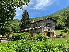 Natursteinhaus mit Holzfenstern in Alleinlage bei Arco am Gardasee, umgeben von Wiesen, Bergen und Kastanienwald – ideal für Familienurlaub in der Natur I WUNDERORTE