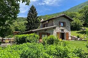 Natursteinhaus mit Holzfenstern in Alleinlage bei Arco am Gardasee, umgeben von Wiesen, Bergen und Kastanienwald – ideal für Familienurlaub in der Natur I WUNDERORTE