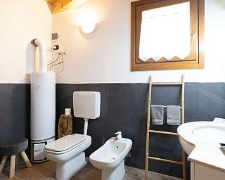 Helles Badezimmer mit Bidet, WC und Fenster in einem Landhaus in Italien von WUNDERORTE