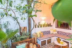 Mediterrane Terrasse mit Pool-Blick, romantisch unter Palmen, Dekoration natürlich  in farblich abgestimmten Pasteltönen