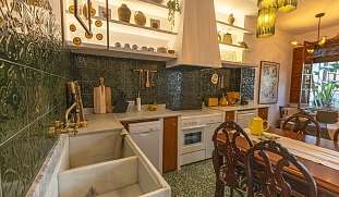 Mediterrane Designküche mit grünen Fliesen, Naturmaterialien und Essbereich  - ideale Unterkunft für Familien in Spanien  I WUNDERORTE