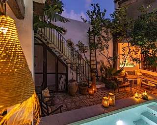 Abendlich beleuchteter mediterraner Patio mit beleuchtem Pool Lichtern &amp; Lounge Bereich I WUNDERORTE