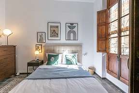Schlafzimmer mit Fenster und Kunstdrucke an der Wand mediterrane Ruhe bei WUNDERORTE