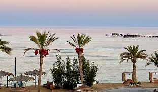 Romantische Hotelanlage  mit Palmen und Meerblick in Ägypten bei Sonnenuntergang