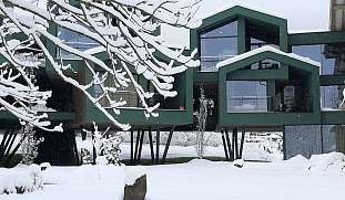 Verschneites Design-Boutiquehotel in den Dolomiten mit moderner Sauna- und Hotelanbindung