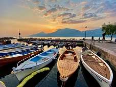 Traditionelle Holzboote bei Sonnenuntergang im Hafen am Gardasee – mediterrane Ruhe und Urlaubsglück am Wasser | WUNDERORTE