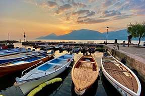 Traditionelle Holzboote bei Sonnenuntergang im Hafen am Gardasee – mediterrane Ruhe und Urlaubsglück am Wasser | WUNDERORTE