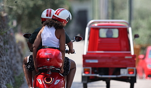 Roter Oldtimer und Vespa am Gardasee in typisch passend traditioneller italienischerUmgebung