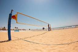 Volleyballnetz am Sandstrand mit Palmen und Spielern – sportliche Atmosphäre am Hotel The Breakers in Soma Bay