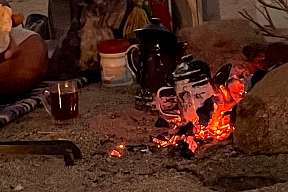 Offenes Feuer mit Teekannen und typischem Beduinensetup in der Wüste bei Dämmerung – authentisches Erlebnis mit WUNDERORTE