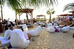 Gäste entspannen in Strandlounge mit Palmen und Meerblick – gemeinsamer Moment am The Breakers