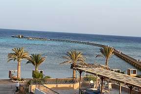 Blick über Palmen, Strand und Jetty auf das türkisblaue Rote Meer am Hotel The Breakers in Soma Bay