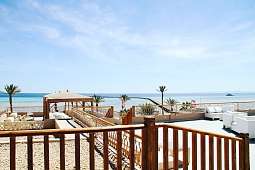 Weiße Loungemöbel auf der Rooftop-Terrasse mit Blick über das Rote Meer und den Jetty des Hotels The Breakers in Ägypten
