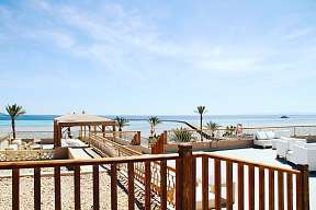 Weiße Loungemöbel auf der Rooftop-Terrasse mit Blick über das Rote Meer und den Jetty des Hotels The Breakers in Ägypten