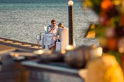 Ein Paar genießt ein stilvolles Dinner bei Sonnenuntergang auf einem Steg am Roten Meer – Luxusmoment für Flitterwochen in Ägypten