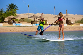 Zwei Urlauber beim Stand-up-Paddling und Kitesurfen im flachen Wasser am Strand von Soma Bay – sportlicher Aktivurlaub am Hotel The Breakers in Ägypten