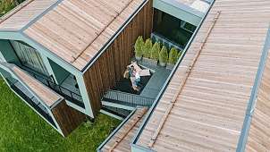 Paar auf privater Terrasse eines Luxus-Chalets in Südtirol – Rückzugsort für Ruhe, Natur &amp; Design