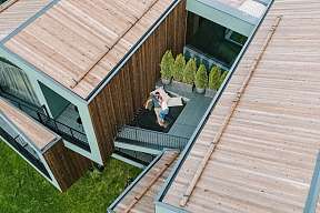 Paar auf privater Terrasse eines Luxus-Chalets in Südtirol – Rückzugsort für Ruhe, Natur &amp; Design