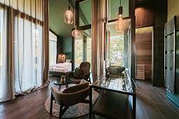 Innenaufnahme einer luxuriösen Designsuite mit stilvollem Interieur, privater Sauna und Blick ins Grüne – Rückzugsort in Südtirol bei WUNDERORTE