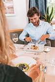 Ein Paar genießt ein stilvolles Dinner mit feiner Küche und Weißwein in einem romantischen Wellnesshotel in Tirol – kulinarische Verwöhnmomente I WUNDERORTE