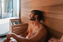 Ein Mann entspannt in der privaten Sauna eines Boutique-Chalets in Tirol – Wärme, Stille und neue Energie I WUNDERORTE