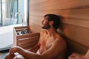 Ein Mann entspannt in der privaten Sauna eines Boutique-Chalets in Tirol – Wärme, Stille und neue Energie I WUNDERORTE