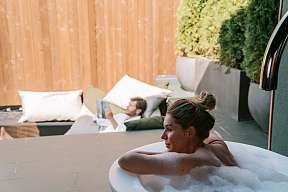 Frau im privaten Outdoor-Whirlpool, Rückzugsort für Wellness, Ruhe und Design in Südtirol – WUNDERORTE