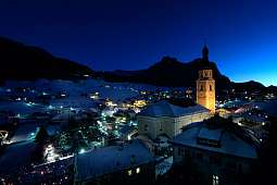 Beleuchtete Kirche und verschneite Dächer in Kastelruth bei Nacht – stimmungsvolle Winterlandschaft für einen ruhigen Adventurlaub in Südtirol I WUNDERORTE