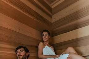 Ein Paar entspannt gemeinsam in der privaten Sauna einer luxuriösen Wellness-Suite in Südtirol – Wärme, Ruhe und Rückzug I WUNDERORTE