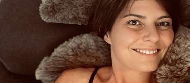 Frau liegt entspannt auf weichem Kissen und lächelt – Symbol für Achtsamkeit, Wohlfühlen und innere Balance mit WUNDERORTE