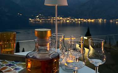 Grappa-Genuss auf der Terrasse mit Blick über den abendlichen Gardasee“