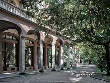 Historischer Arkadengang am Designloft in Meran, umgeben von altem Baumbestand im Park I WUNDERORTE