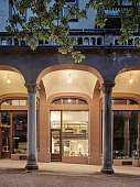 Beleuchtetes Designloft in Meran mit hohen Fenstern und stilvollem Innenraum am Abend I WUNDERORTE