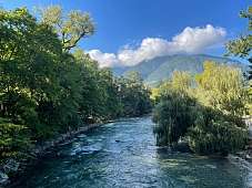 Klarer Flusslauf der Passer umgeben von dichter Vegetation und bewaldeter Bergkulisse bei Meran I WUNDERORTE