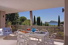 Frühstückstisch auf der Terrasse einer Lamasu-Ferienwohnung am Gardasee mit Zypressen, See-Panorama und mediterranem Flair I WUNDERORTE