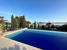Infinity-Pool der Ferienresidenz Lamasu am Gardasee mit Glasbrüstung, Palmen und weitem Panoramablick I WUNDERORTE