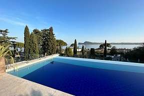 Infinity-Pool der Ferienresidenz Lamasu am Gardasee mit Glasbrüstung, Palmen und weitem Panoramablick I WUNDERORTE