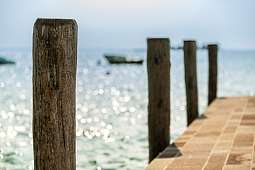 Sonnendurchfluteter Holzsteg mit Blick auf den Gardasee – idealer Seezugang für Gäste des WUNDERORTE Wellnessresorts I WUNDERORTE