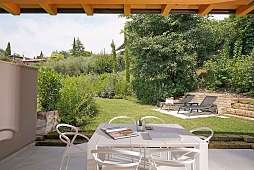Gartenterrasse einer Lamasu-Ferienwohnung am Gardasee mit Esstisch, Liegewiese und direktem Seezugang I WUNDERORTE