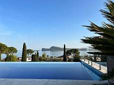 Infinity-Pool der Ferienresidenz Lamasu am Gardasee mit Glasbrüstung, Palmen und weitem Panoramablick I WUNDERORTE