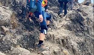 Bergsteigerinnen beim Aufstieg auf den Kilimandscharo, konzentriert und gesichert auf felsigem Terrain in Tansania