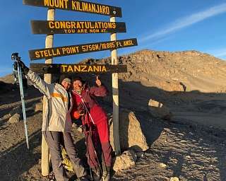 Zwei glückliche Bergsteigerinnen Stella Point des Kilimandscharo in Tansania bei Sonnenaufgang