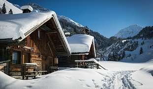 Eingeschneite Berghütte Weihnachtlicher Winterzauber – Skireisen mit Herz und Naturerlebnis.